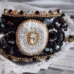 Bracciale nero sacro ricamato su un pizzo nero antico 